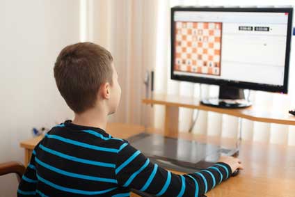 kid playing chess on computer